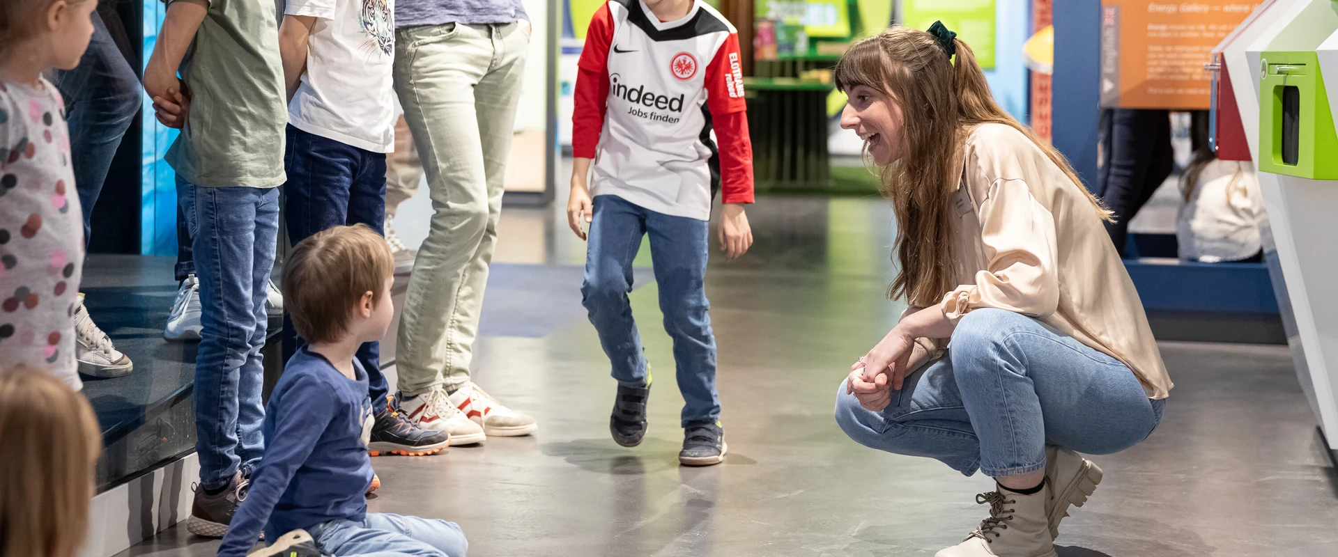 Kindergruppe mit Besucherbetreuerin in der Ausstellung der KLIMA ARENA.