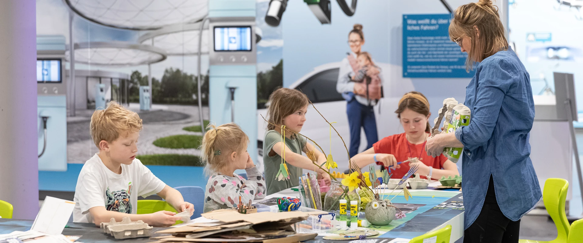 Kinder am Basteltisch in der Ausstellung der KLIMAARENA.
