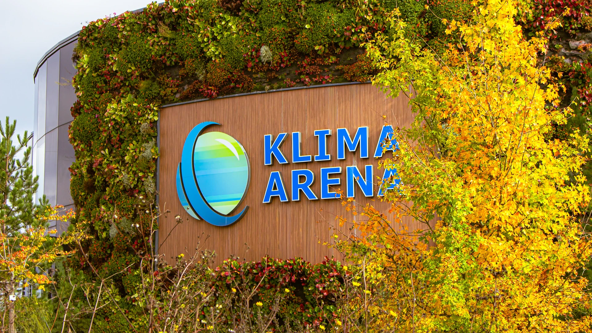 Eine Ansicht der begr&uuml;nten Logowand des Klima Arena Geb&auml;udes von Au&szlig;en