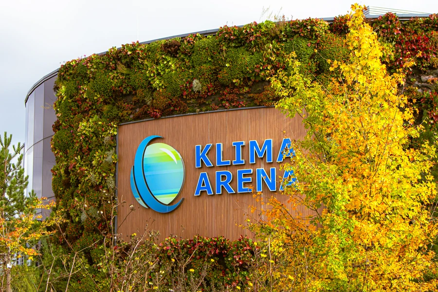 Eine Ansicht der begr&uuml;nten Logowand des Klima Arena Geb&auml;udes von Au&szlig;en