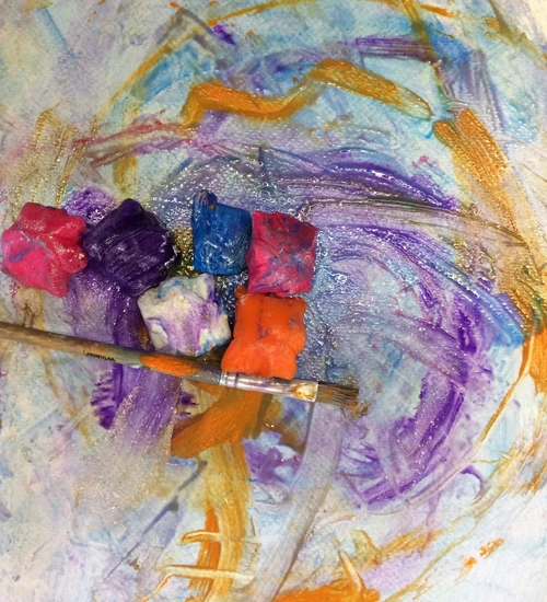 Auf dem Bild sind Eisw&uuml;rfel zu sehen, die auf bunten, verlaufenden Aquarellfarben liegen.